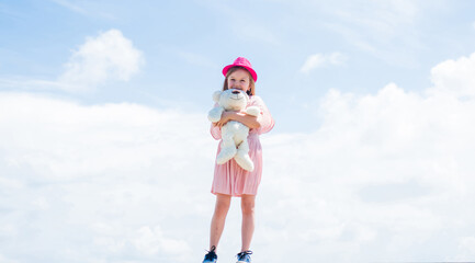 cute child on sky background. spring season weather. summer fashionable look. freedom. beautiful teen girl with teddy bear toy. kid fashion style. female natural beauty. happy childhood