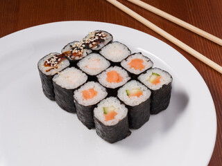set of small sushi rolls on a white plate