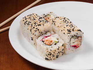 sushi roll with salmon and sesame on a white plate
