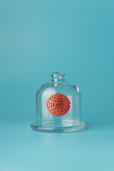 Covid-19 virus model under glass protect dome on blue background. Coronavirus under control or...