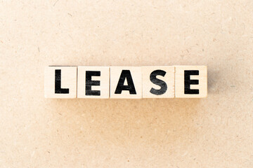 Alphabet letter block in word lease on wood background