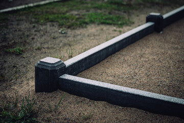 border of grave site made of concrete. Gravel inside. 