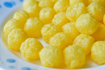 Yellow round corn snacks with cheese flavor