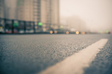 Morning fog in the city, the empty road. Close up view from the level of the dividing line
