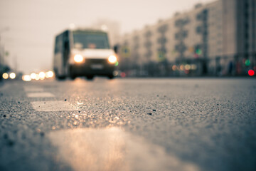 Morning fog in the city, the headlights of an approaching van. Close up view from the level of the dividing line