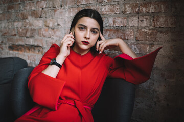 Stylish lady with smartphone in creative workspace