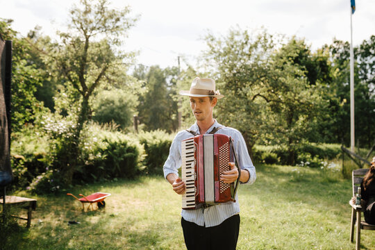 Man playing accordion in garden