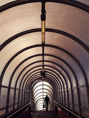 Man silhouette in symmetrical tunnel; color photo.