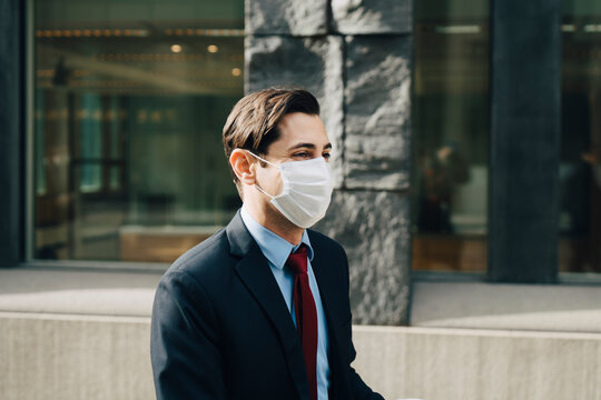 Businessman with protective face mask by office building