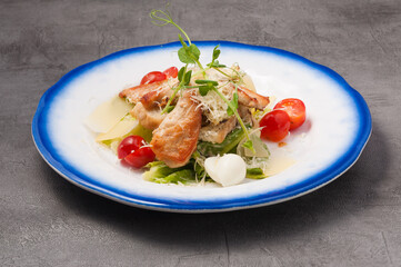 Caesar salad with chicken on a gray background