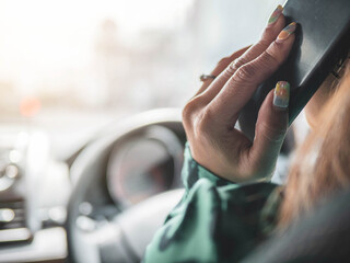 Women using smart phone while driving a car.