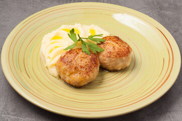 puree with butter and chicken cutlets decorated with a parsley leaf