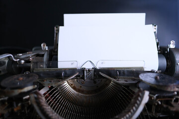 old typewriter on table, blank white sheet for text, mockup, retro style, concept of works of a...