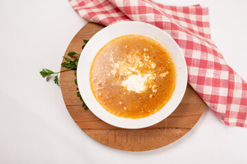 cabbage soup with sour cream and dill on a white wooden background, top view