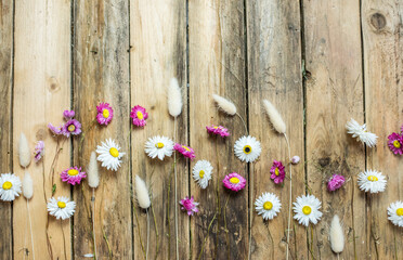 Dekoration mit Trockenblumen auf hölzernen Untergrund, getrocknete Gräser und Blumen