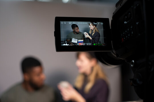 Businesswoman explaining about product with male colleague while recording on camera in office