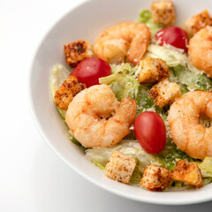 Cooked shrimp or prawn with vegetables, croutons and Cherry tomatoes. Spicy oriental dish, Pan-Asian cuisine. Part of food plate on white background. Soft focus. Close up shot.