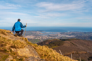 A young hiker looking at the views of the towns of Hondarribia and Hendaya from the mountains of Aiako Harria or Peñas de Aya, Guipúzcoa. Basque Country