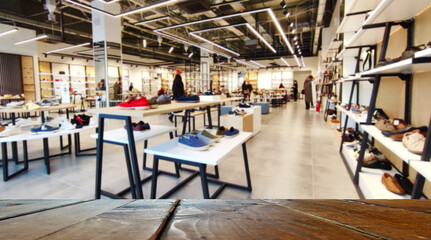 Desk top or empty blank counter with blurred shoe store on background.