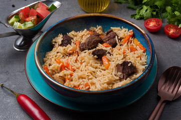 traditional Oriental dish: pilaf with beef and vegetable salad