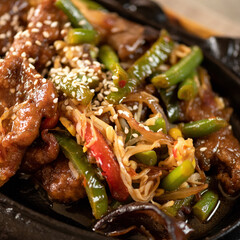 Colorful appetizing wok noodles dish with sesame seeds and vegetables. Spicy oriental dish, Pan-Asian cuisine. Soft focus. Close up shot.