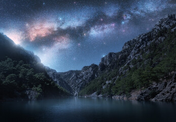 Milky Way and stars over beautiful mountain canyon and blue sea at night in summer. Colorful...
