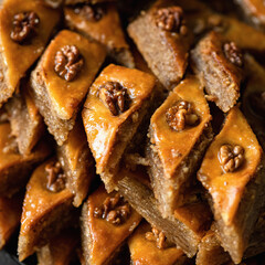 Honey baklava with nuts. Traditional oriental dessert or sweetness dish, close up. Pieces of sweet puff pastry with walnuts. Food background. Soft focus.
