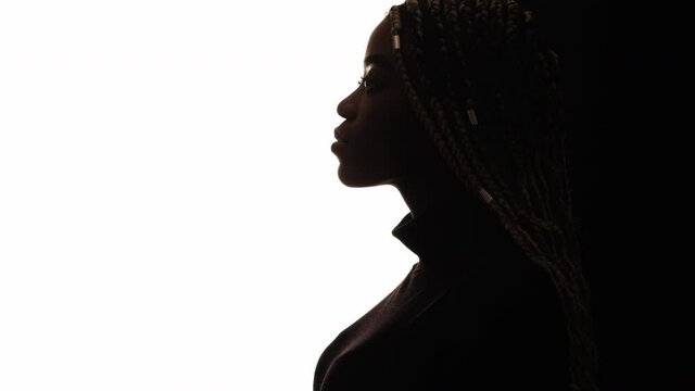 Silhouette female portrait. Black lives matter. Feminine nature. Conscious mind. Conceptual art. Profile african woman with cornrows looking copy space isolated white.