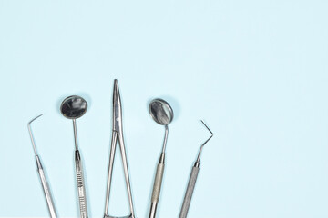 Medical dental instruments on light blue background with copy space. Flat lay close up top view on dental equipment. dental mirrors, probes, forcepts