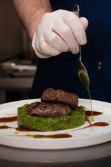 the chef prepares chops with spinach before serving the dish