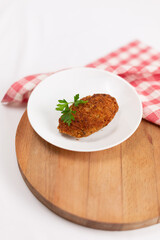 Poultry cutlet decorated with parsley on a white background
