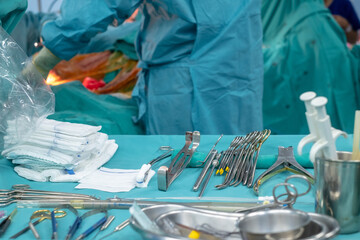 Medical team performing operation. Close up of scrub nurse taking medical instruments for operation. Medical and instrumentalist nurse working in an operating room with scissors of surgery.