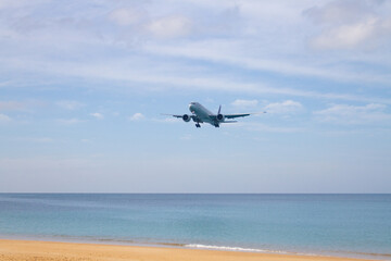 Fototapeta na wymiar The plane is landing over the tropical beach