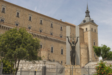 Female statue in the city of Toledo Spain on the background of a building - obrazy, fototapety, plakaty