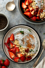 Chia seed pudding bowls with strawberries and oats. Healthy food breakfast, top view. Food scene.