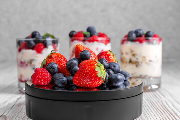 Strawberries, raspberries and blueberries on a twisted table. Muesli with yogurt and berries in glasses. Healthy food concept. Fitness food. High quality photo