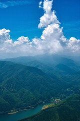 Obraz premium 夏の山間を縫うように流れる川