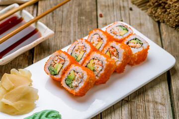 California roll with crab on white plate on old wooden table