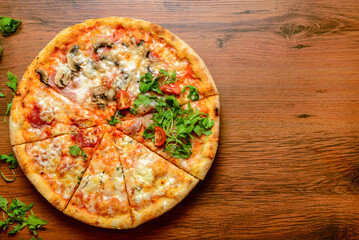 Top down view of a pizza on wooden table.
