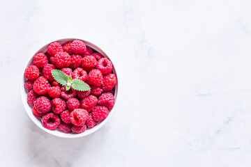 fresh raspberries in a round plate close-up.