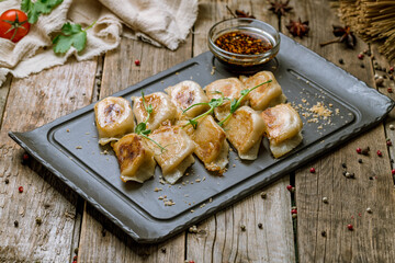 chinese fried dumplings with sauce on old wooden table