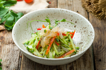 salad with jellyfish and vegetables on old wooden table © bbivirys