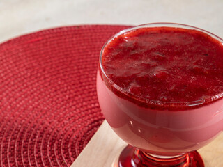 Tasty strawberry mousse in glass with jam on top