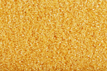 Texture of golden sand on the beach with a solid background in full screen