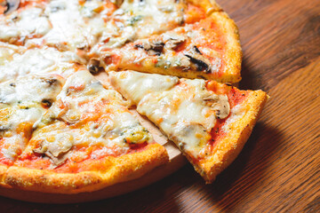 Italian pizza with cheese tomatoes, arugula and mushrooms on wooden cutting board stock photo.