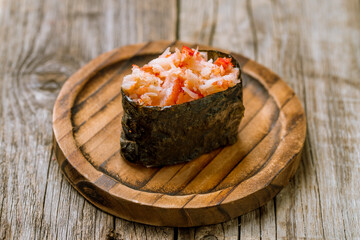 Gunkan sushi with crab on wooden plate on old wooden table © bbivirys
