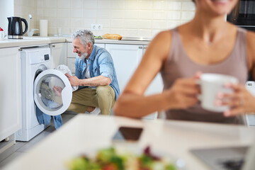 Delighted man helping his partner around the house