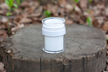 A white jar of cosmetics on a felled tree in the forest
