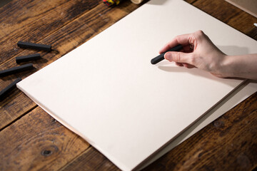 Close-up view of a painter on a white sheet. A man holds a pencil and draws. Drawing and creativity...