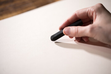 Close-up view of a painter on a white sheet. A man holds a pencil and draws. Drawing and creativity...